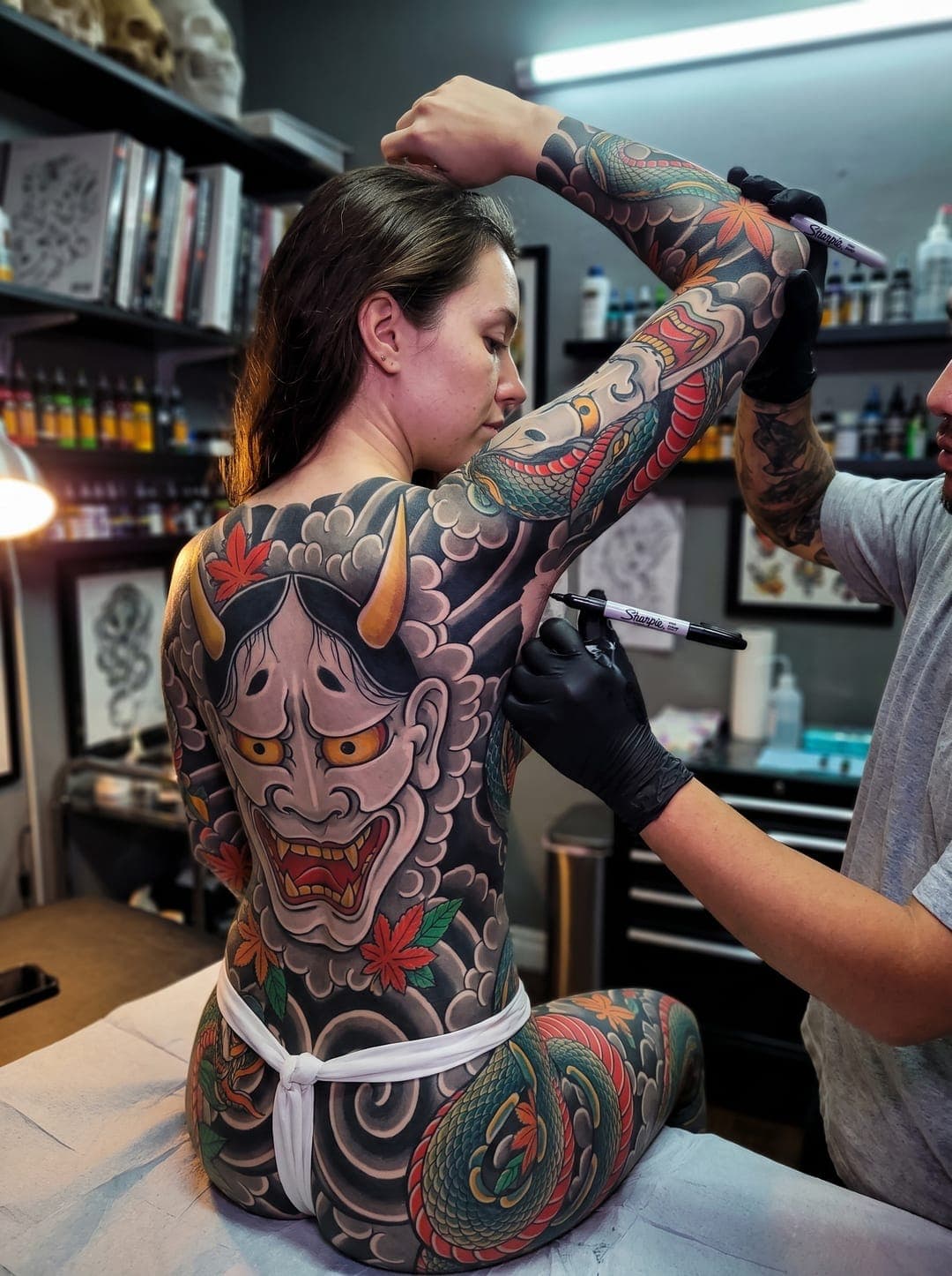 Artist marking up the next session on a hannya backpiece