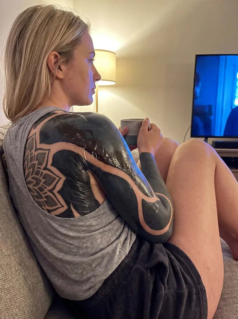 Blackout tattoo idea on a woman — aftercare night wrapped couch