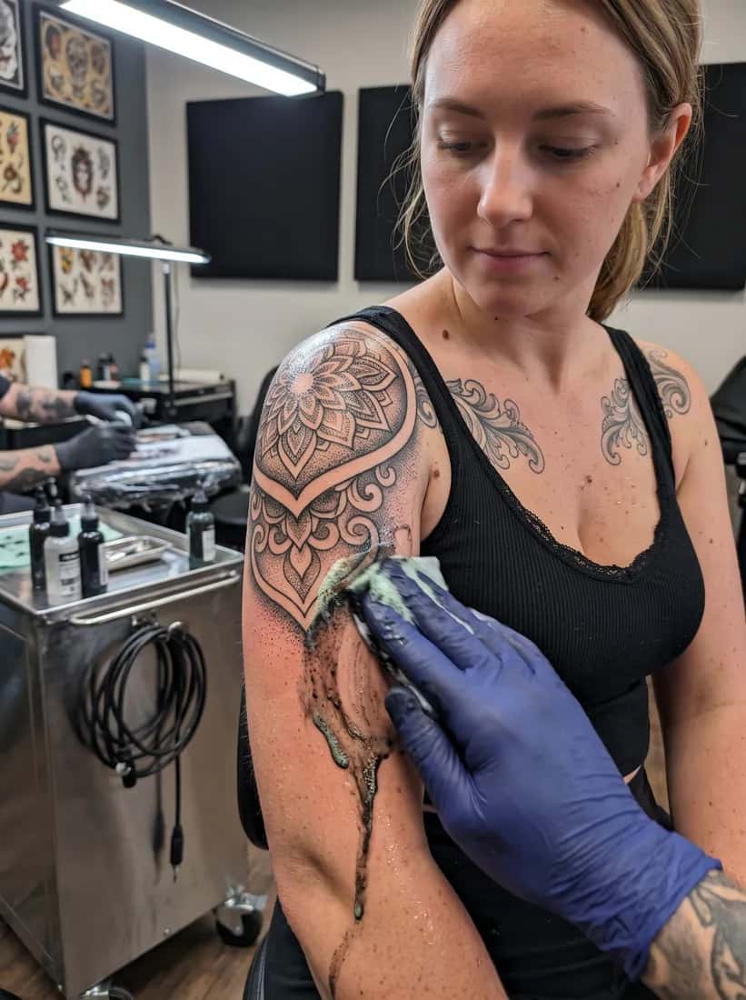 Blackwork tattoo idea on a woman — session wipe greensoap